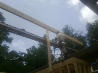 Carpenter setting a ridge beam over a new addition frame — Ice Dam Removal by Roofing Brothers in Roans Prairie