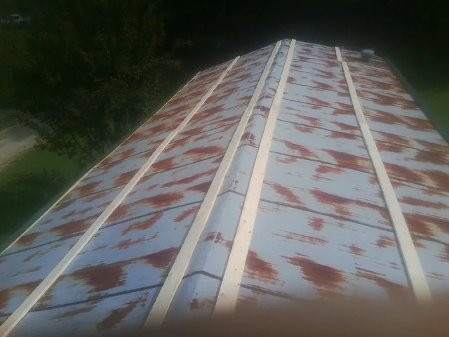 Rusted metal roof panels with new wood purlins before replacement — Storm Damage Roof Repair in Roans Prairie by Roofing Brothers